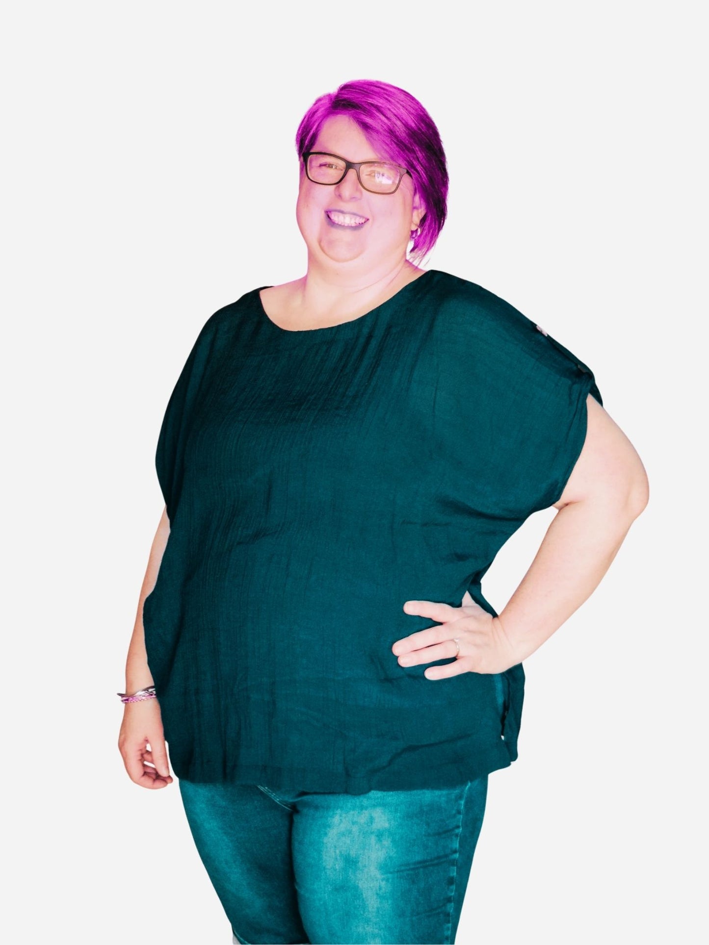 A woman wearing a navy blue blouse with buttons down the back, standing in front of a decorative bird painting.