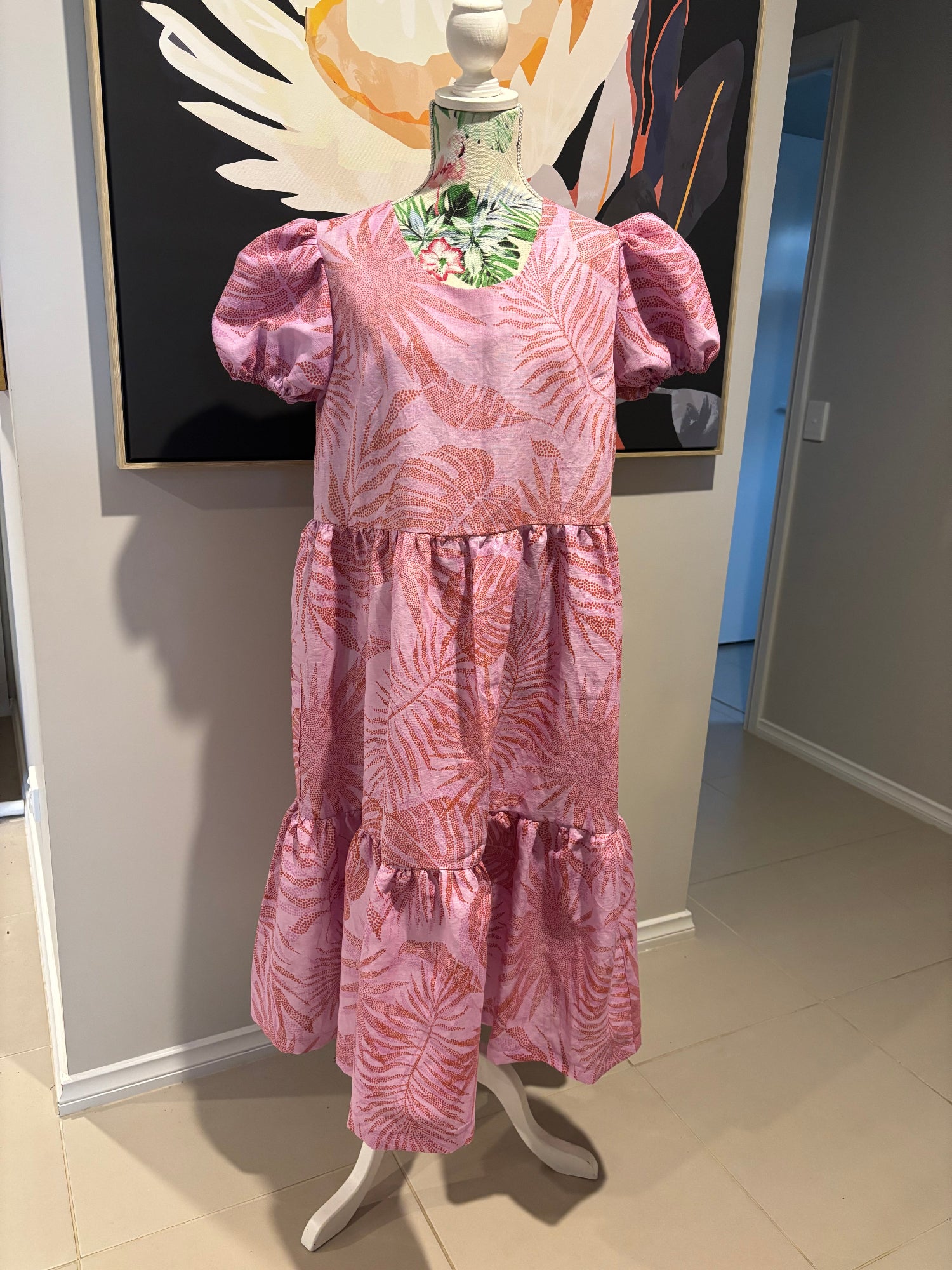 Pink floral dress on a mannequin in a store setting